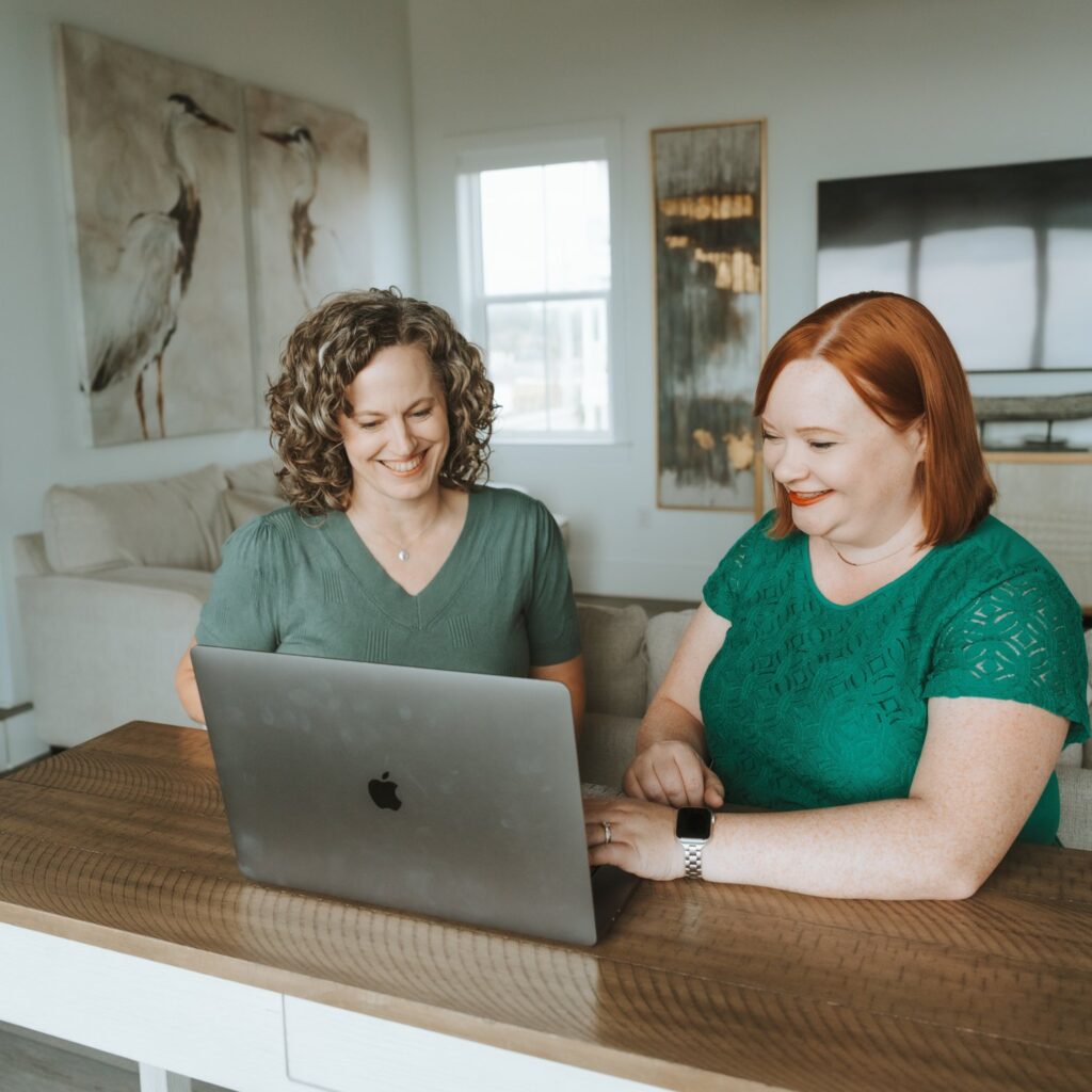 Stephani working with a client at a laptop